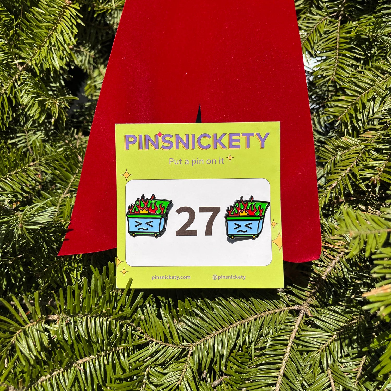 pinsnickety dumpster fire pins in front of a holiday wreath