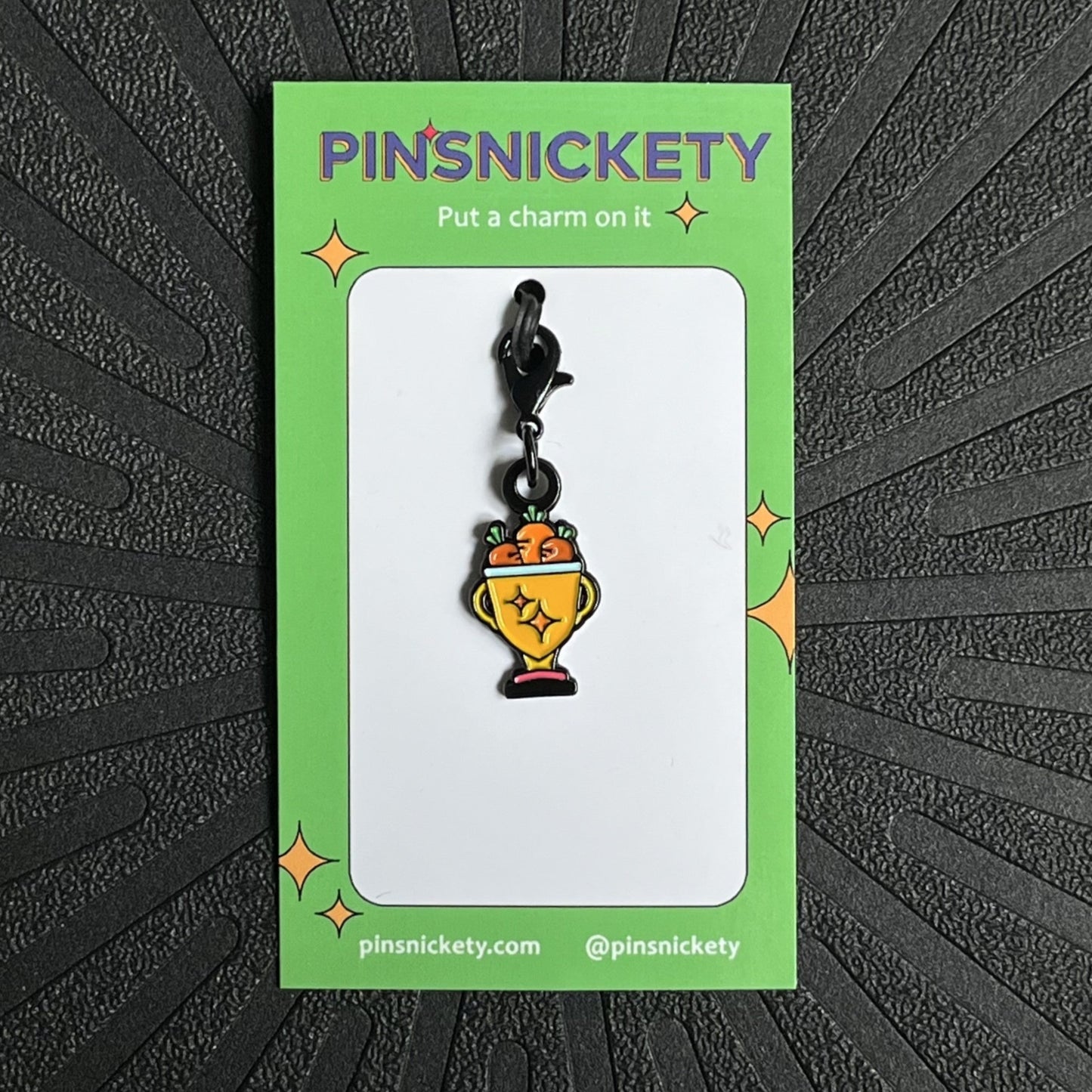 pinsnickety trophy bonnet charm on a black background