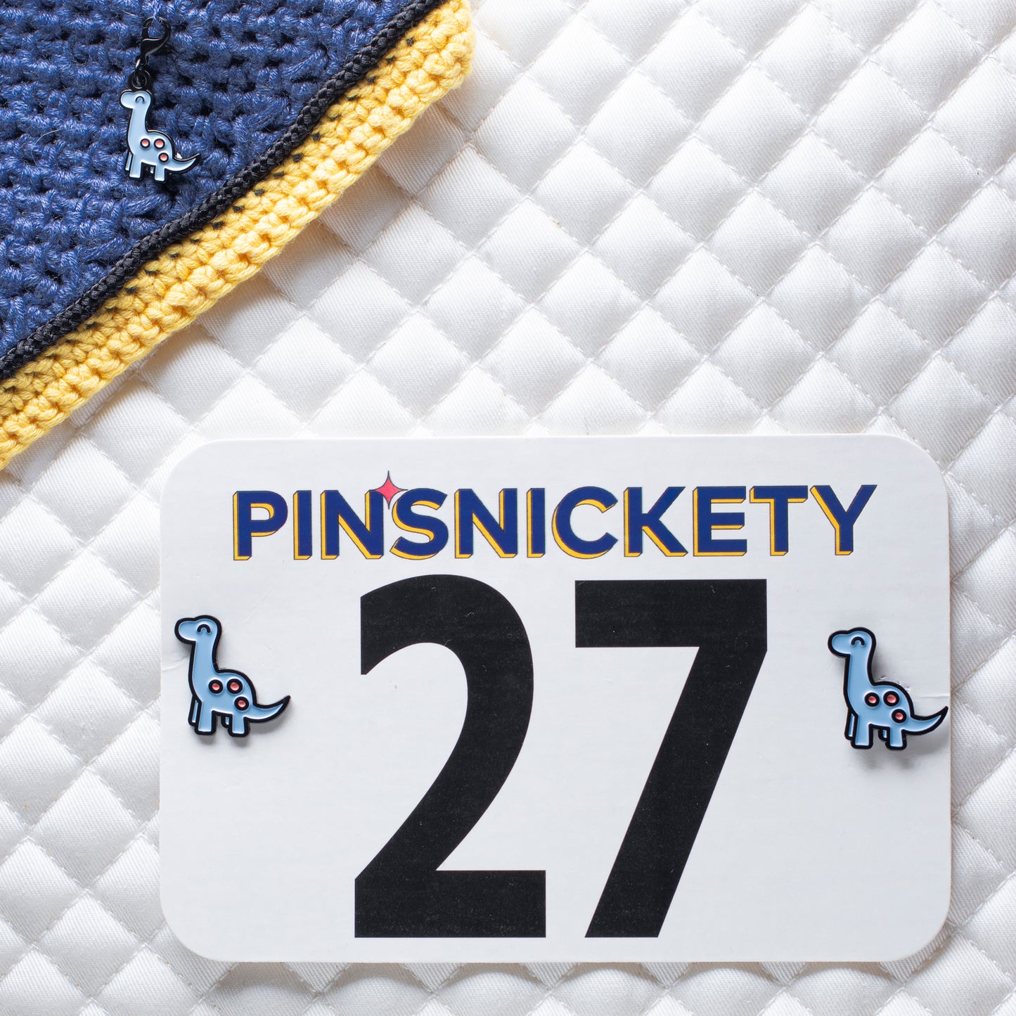 pinsnickety brontosaurus braid and bridle charm on a bonnet and horse show number pins on a saddle pad