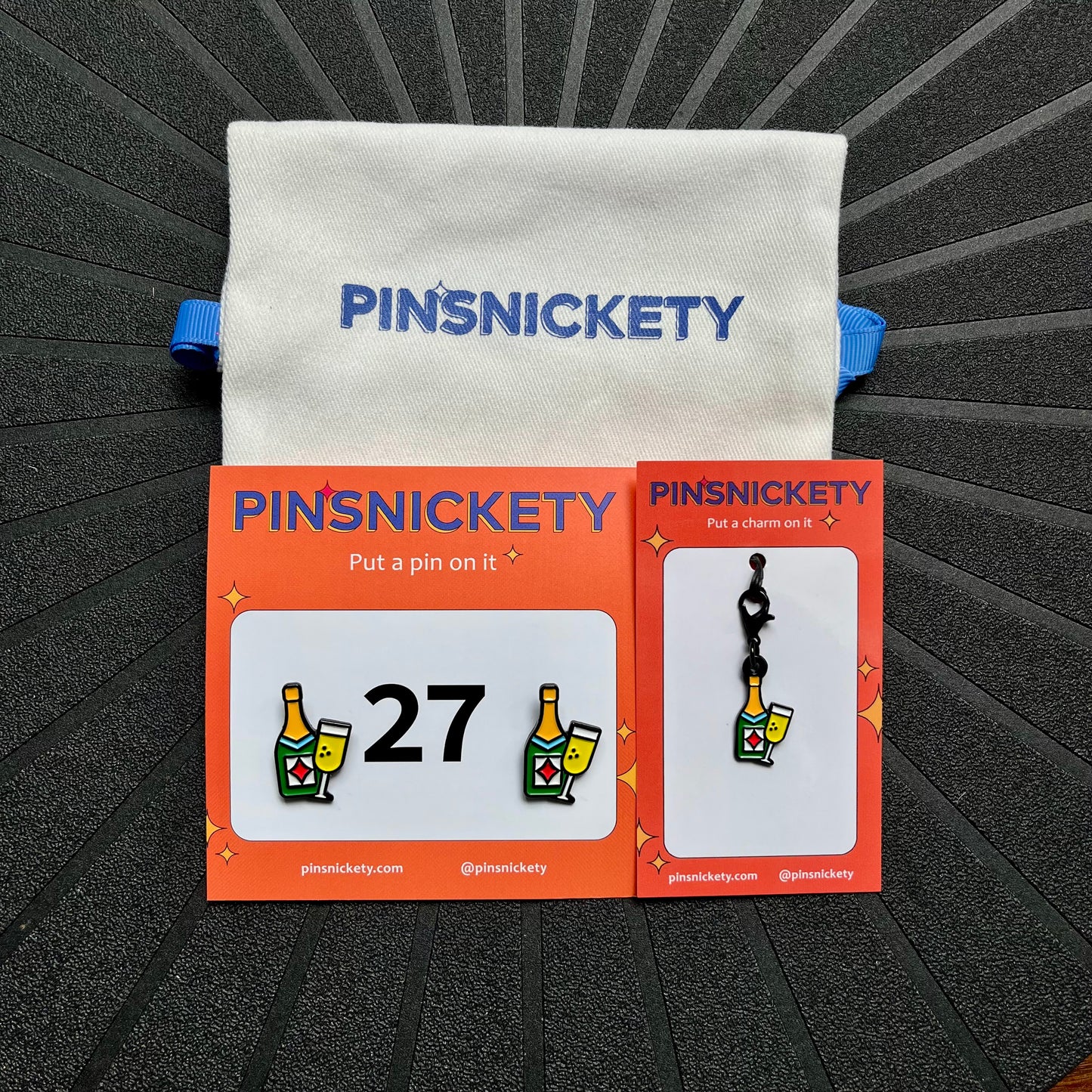 pinsnickety champagne matching set, featuring champagne horse show number pins, champagne bridle charm and twill storage bag against a black background