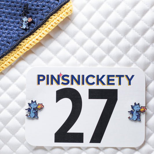 pinsnickety dragon set with a braid and bridle charm on a bonnet and horse show number pins on a saddle pad