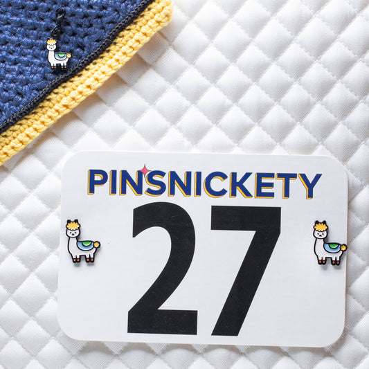 pinsnickety drama llama set, with a drama llama braid and bridle charm on a bonnet and drama llama horse show number pins on a saddle pad