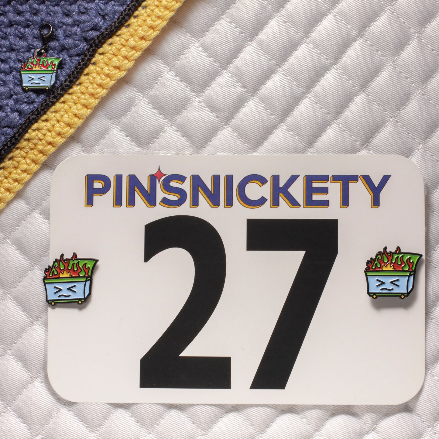 pinsnickety dumpster fire set, featuring dumpster fire horse show number pins on a saddle pad and a dumpster fire bridle charm on a bonnet