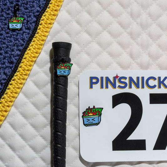 A saddle pad, bonnet and whip decorated with matching Dumpster Pinsnickety horse show number pins, a bridle charm and a crop charm.