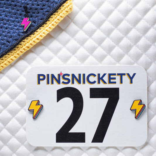 pinsnickety lightning bolt braid and bridle charm on a bonnet and special edition electric yellow lightning bolt horse show number pins on a saddle pad