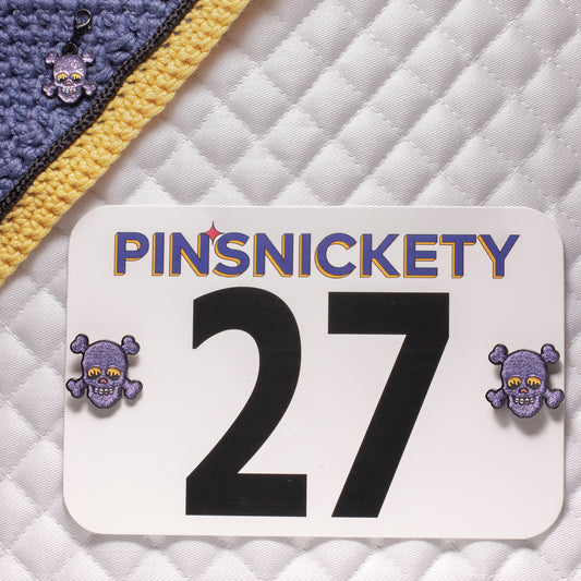 Pinsnickety skull horse show number pins on a saddle pad and skull braid and bridle charm on a bonnet
