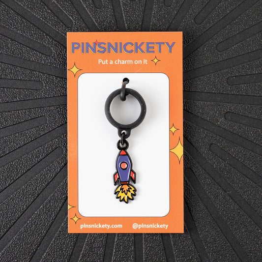 Pinsnickety Rocket Ship crop charm in front of a black background