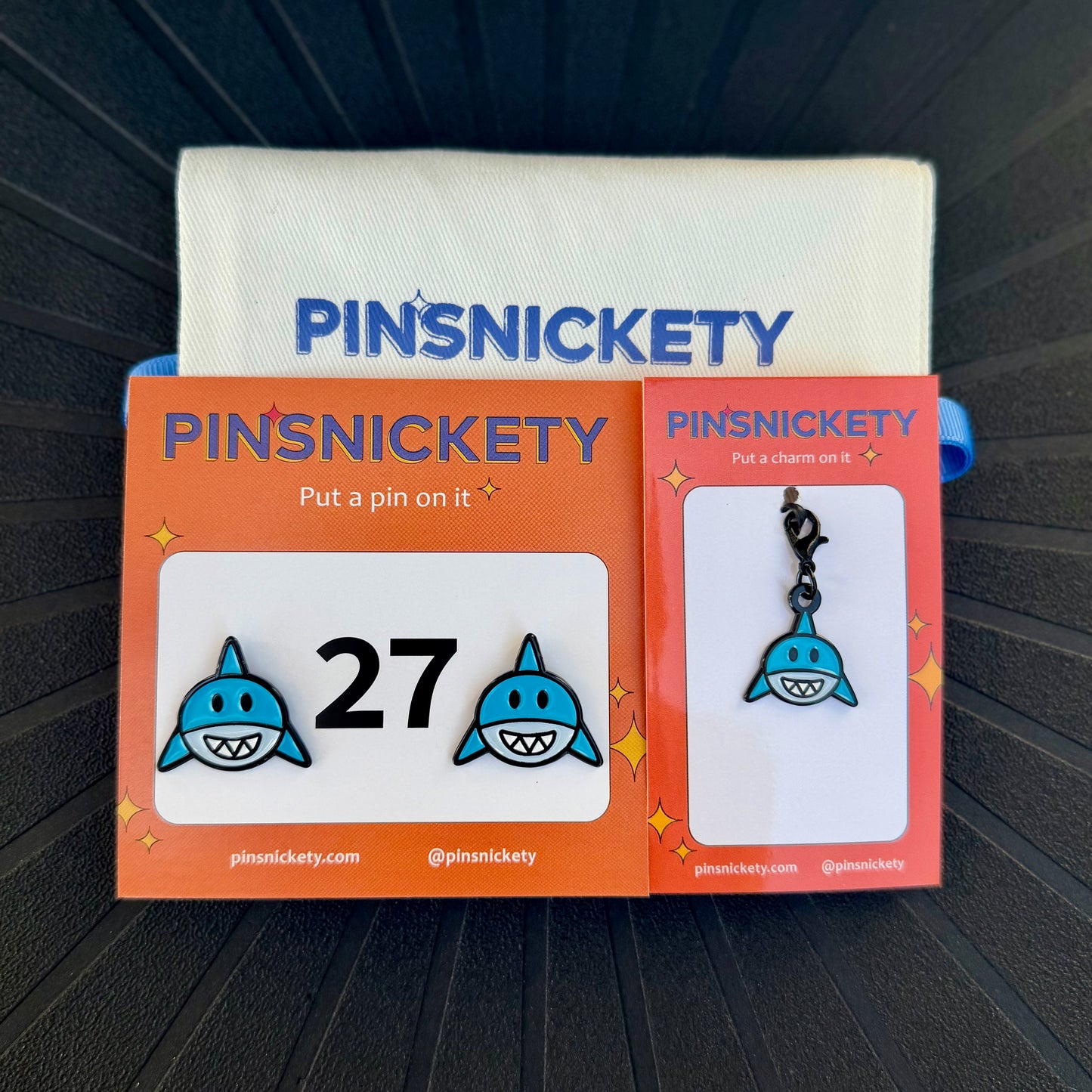 pinsnickety shark horse show number pins and a matching bridle charm on a black background with a deluxe twill storage bag
