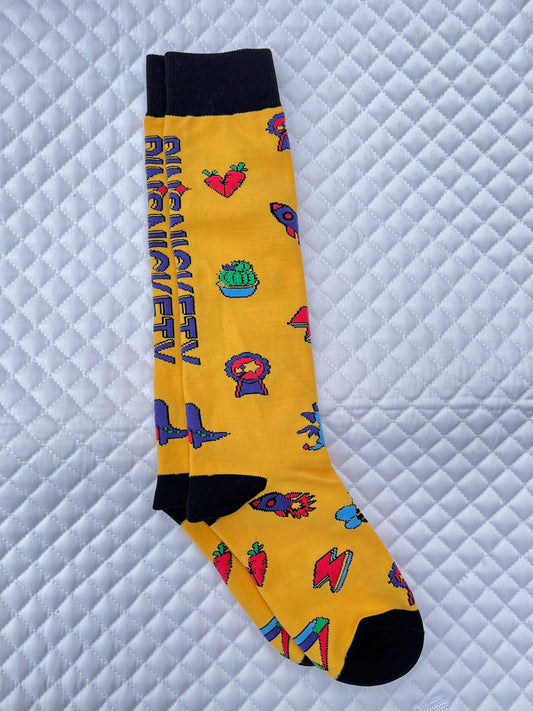 pinsnickety tall boots socks in sunny yellow, covered with pin designs and the company logo, from the right, on a saddle pad