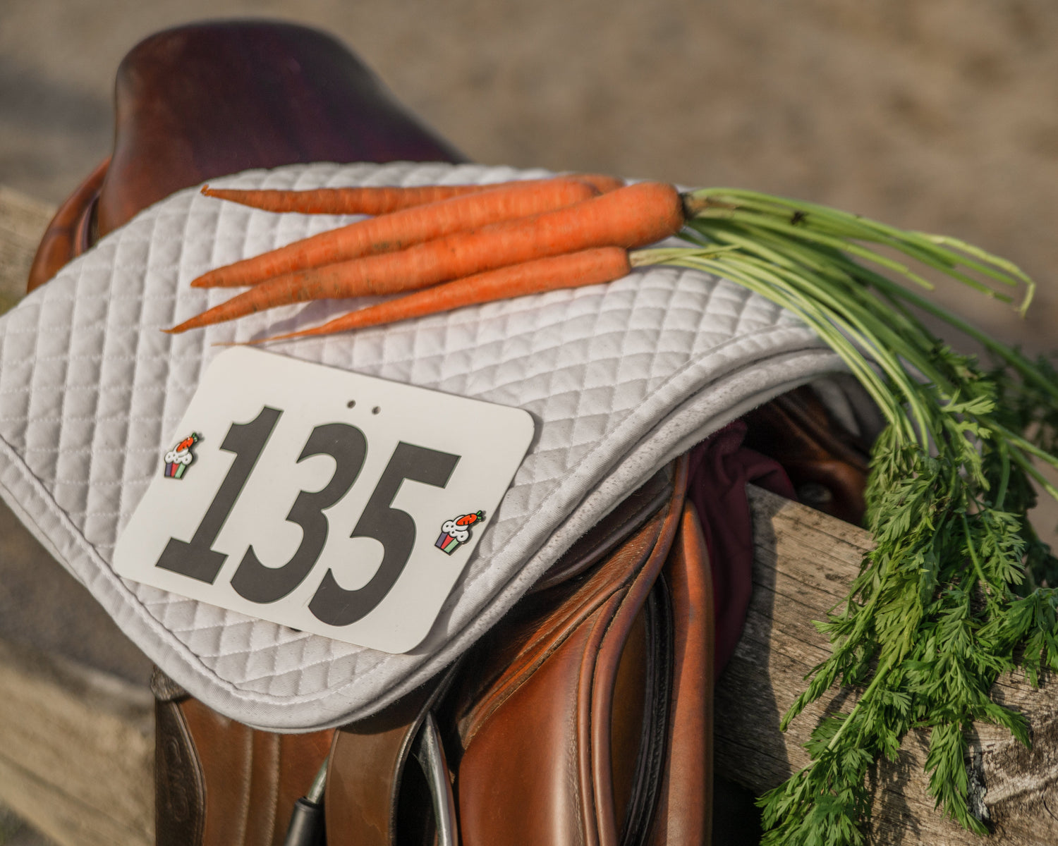 pinsnickety cupcake horse show number pins on a saddle pad draped over a saddle