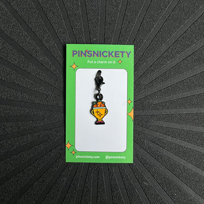 Pinsnickety trophy charm on a black textured background