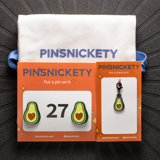 pinsnickety avocado bundle, featuring avocado horse show number pins, an avocado bridle charm, and a pinsnickety twill storage bag, on a black background