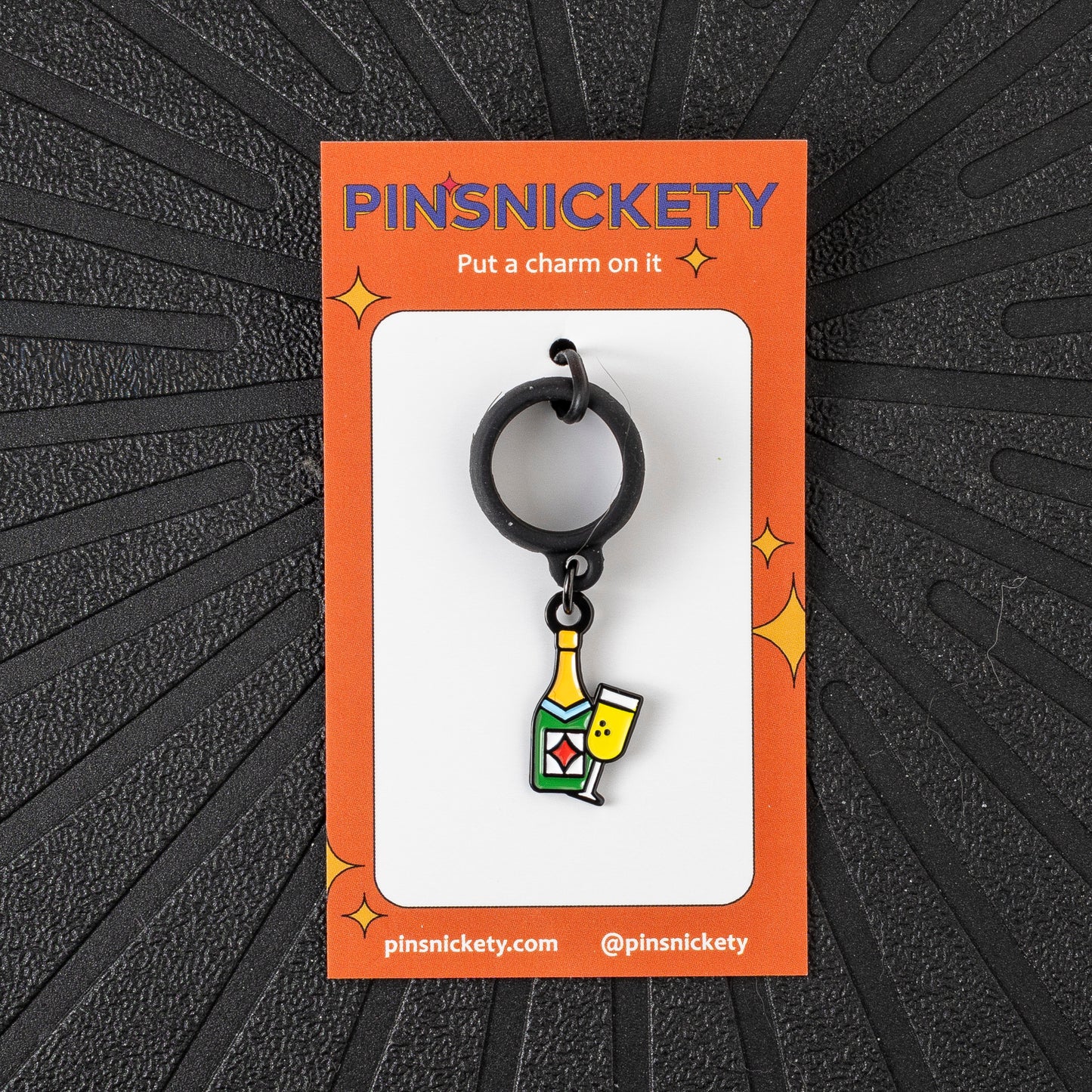 Pinsnickety Champagne crop charm in front of a black background