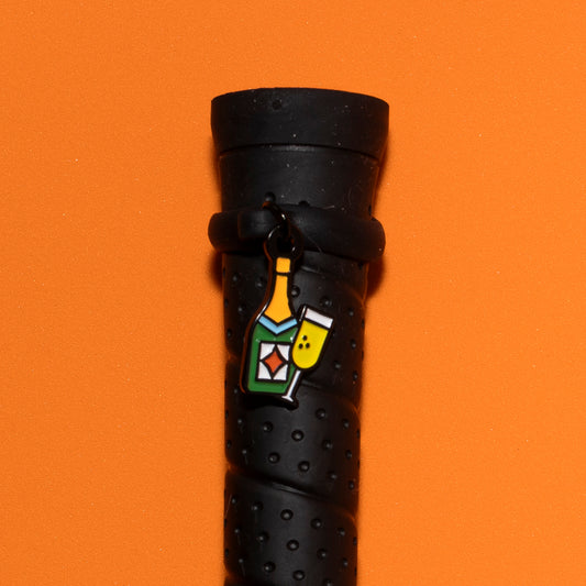 Pinsnickety Champagne crop charm on a whip handle in front of a colored background