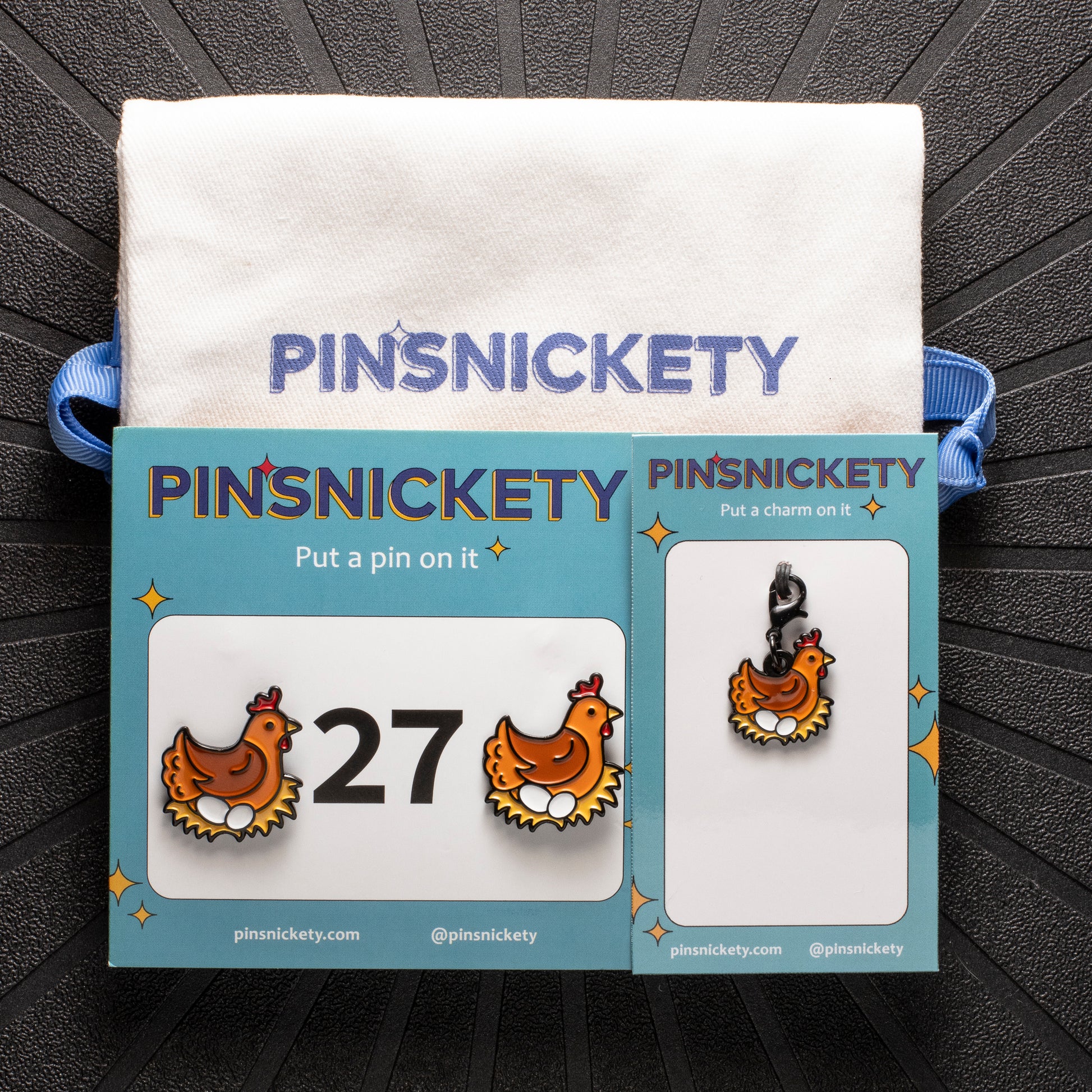 pinsnickety chicken set, featuring chicken horse show number pins, a chicken bridle charm, and a Pinsnickety twill bag