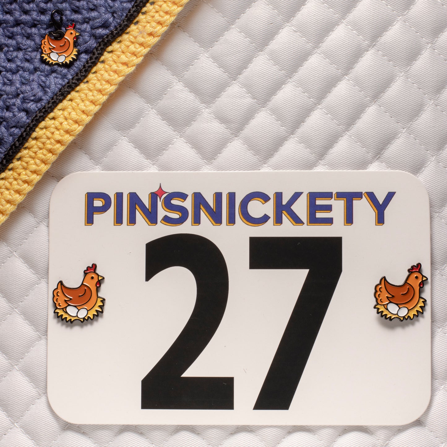 pinsnickety chicken set, featuring chicken horse show number pins on a saddle pad and  a chicken bridle charm on a bonnet