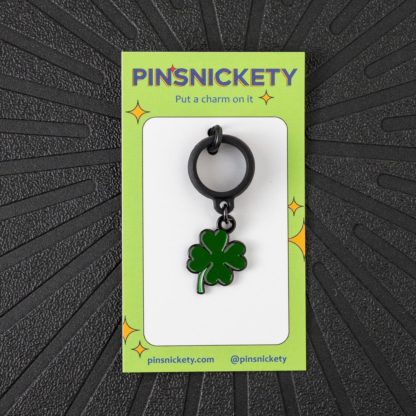 A Pinsnickety Clover crop charm in front of a black background