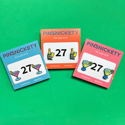 pinsnickety cocktail collection horse show number pins, featuring martini, champagne, and margarita pins on packaging cards from left to right, against a bright green background