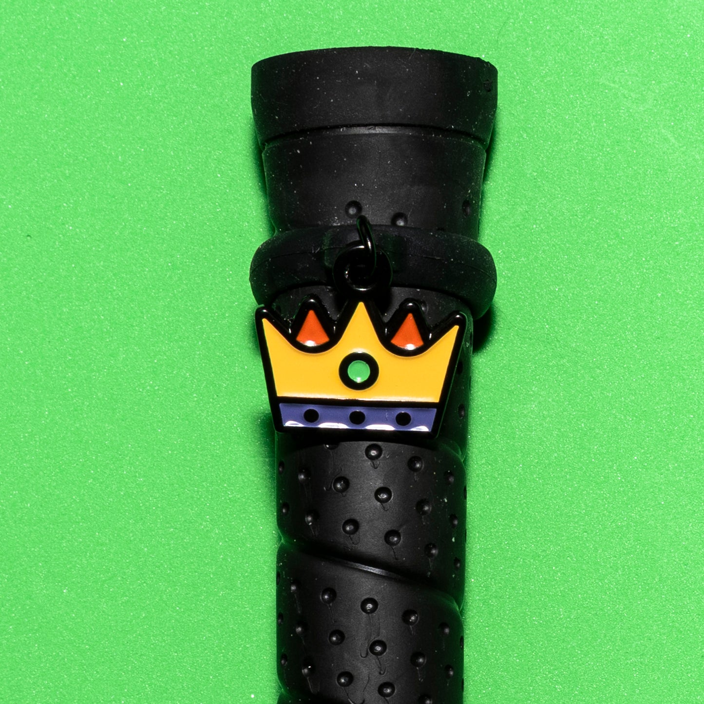 Pinsnickety Crown crop charm on a whip handle in front of a colored background