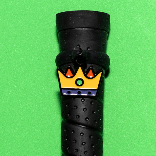 Pinsnickety Crown crop charm on a whip handle in front of a colored background