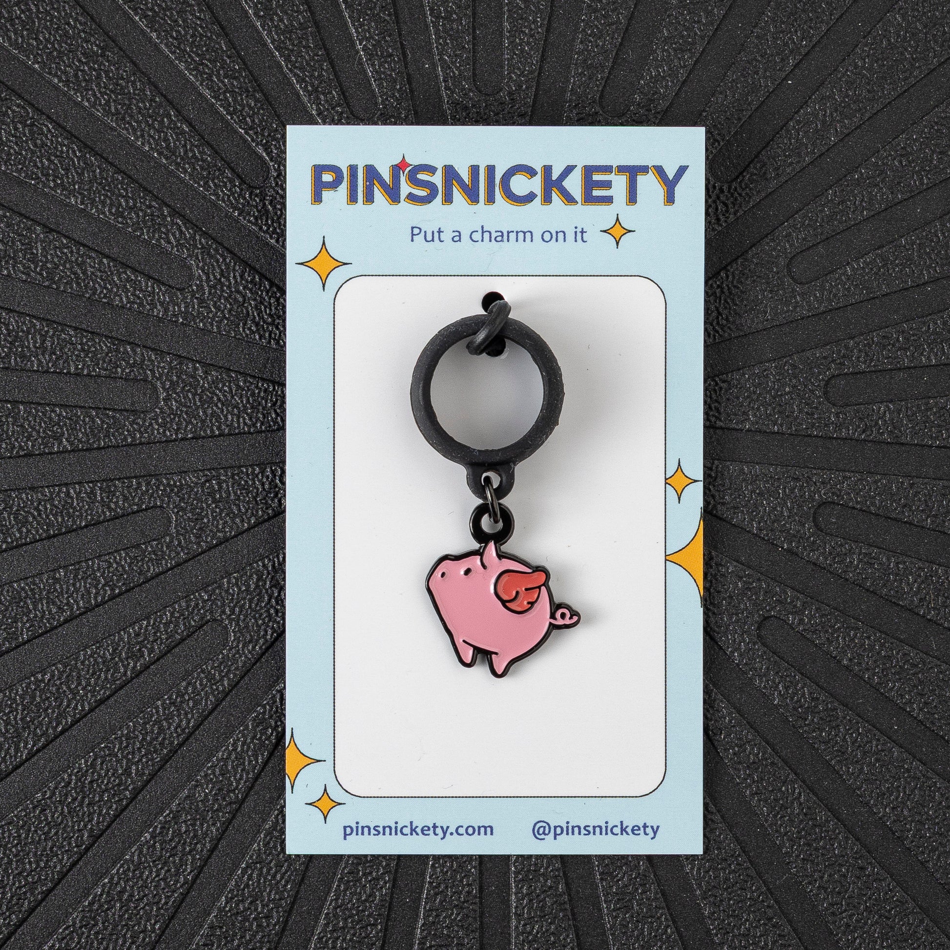 Pinsnickety Flying Pig crop charm in front of a black background