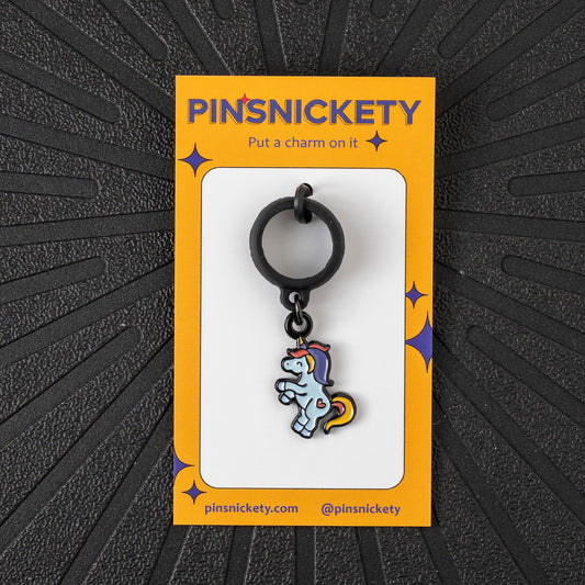 Pinsnickety Flying Unicorn crop charm in front of a black background