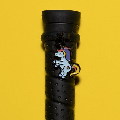 Pinsnickety Flying Unicorn crop charm on a whip handle in front of a colored background
