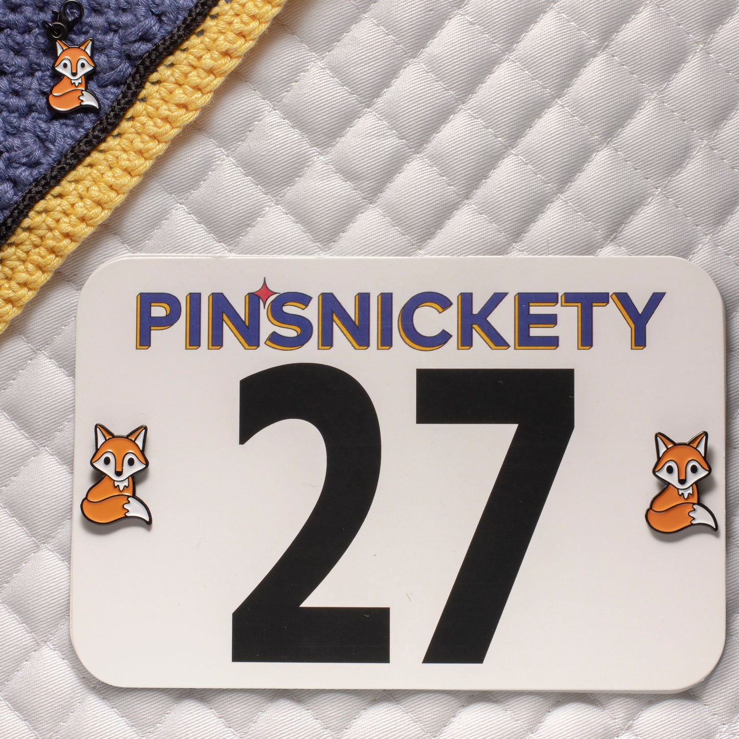 Pinsnickety fox horse show number pins on a saddle pad and fox braid and bridle charm  on a bonnet