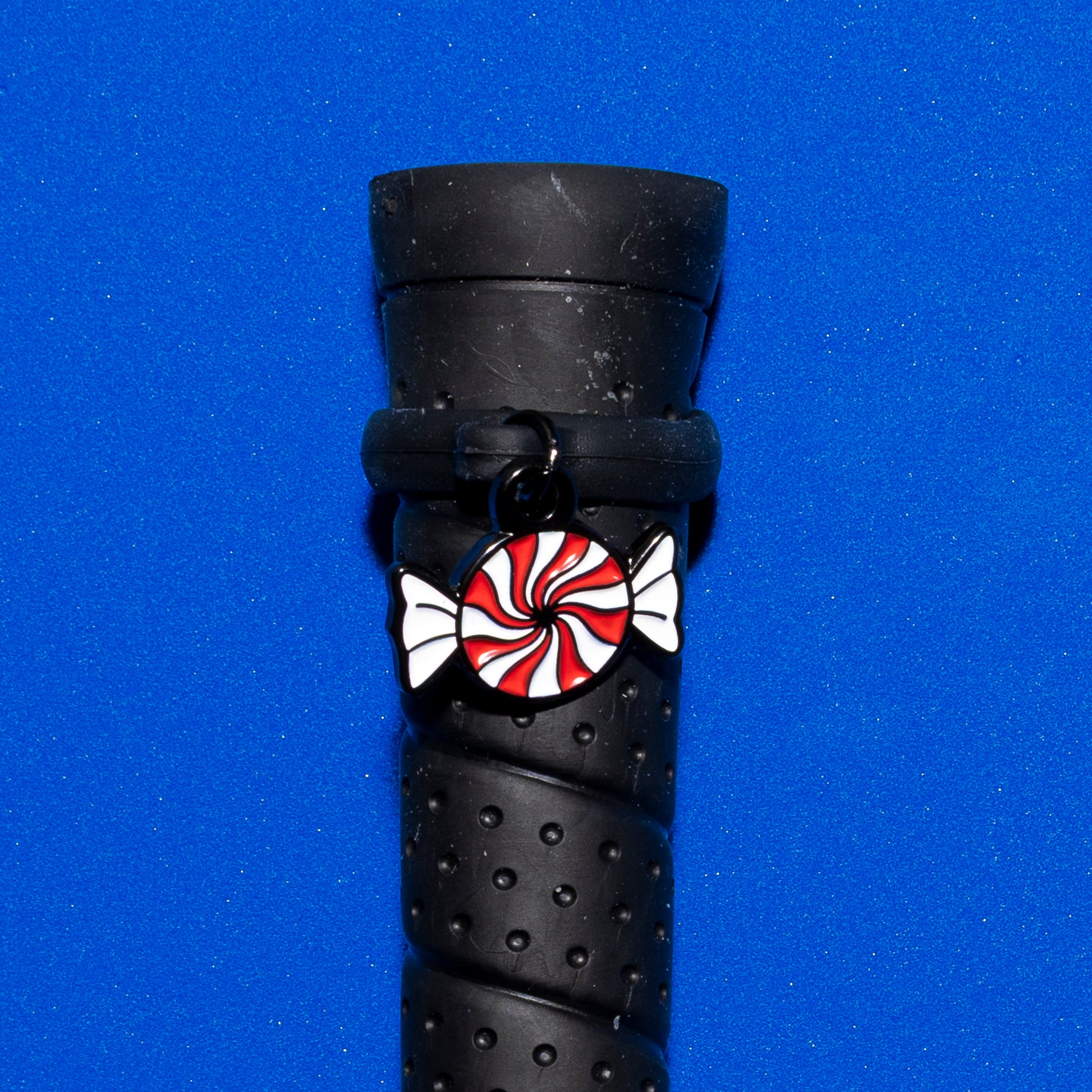 Pinsnickety Peppermint crop charm on a whip handle in front of a colored background