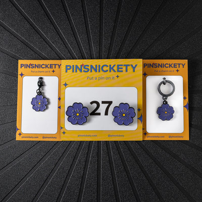 pinsnickety purple poppy triple combination set, including a matching bonnet charm, crop charm, and a pair of horse show number pins in front of a black background.