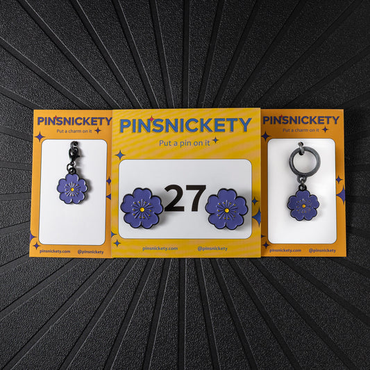 pinsnickety purple poppy triple combination set, including a matching bonnet charm, crop charm, and a pair of horse show number pins in front of a black background.