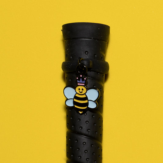 Pinsnickety Queen Bee crop charm on a whip handle in front of a colored background