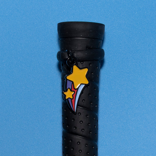 Pinsnickety Shooting star crop charm on a whip handle in front of a colored background