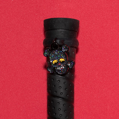 Pinsnickety Skull crop charm on a whip handle in front of a colored background