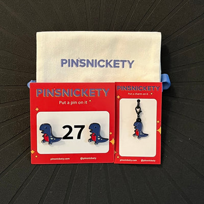 Pinsnickety matching set featuring T-rex horse show number pins, a t-rex braid and bridle charm, and a pinsnickety deluxe twill storage bag