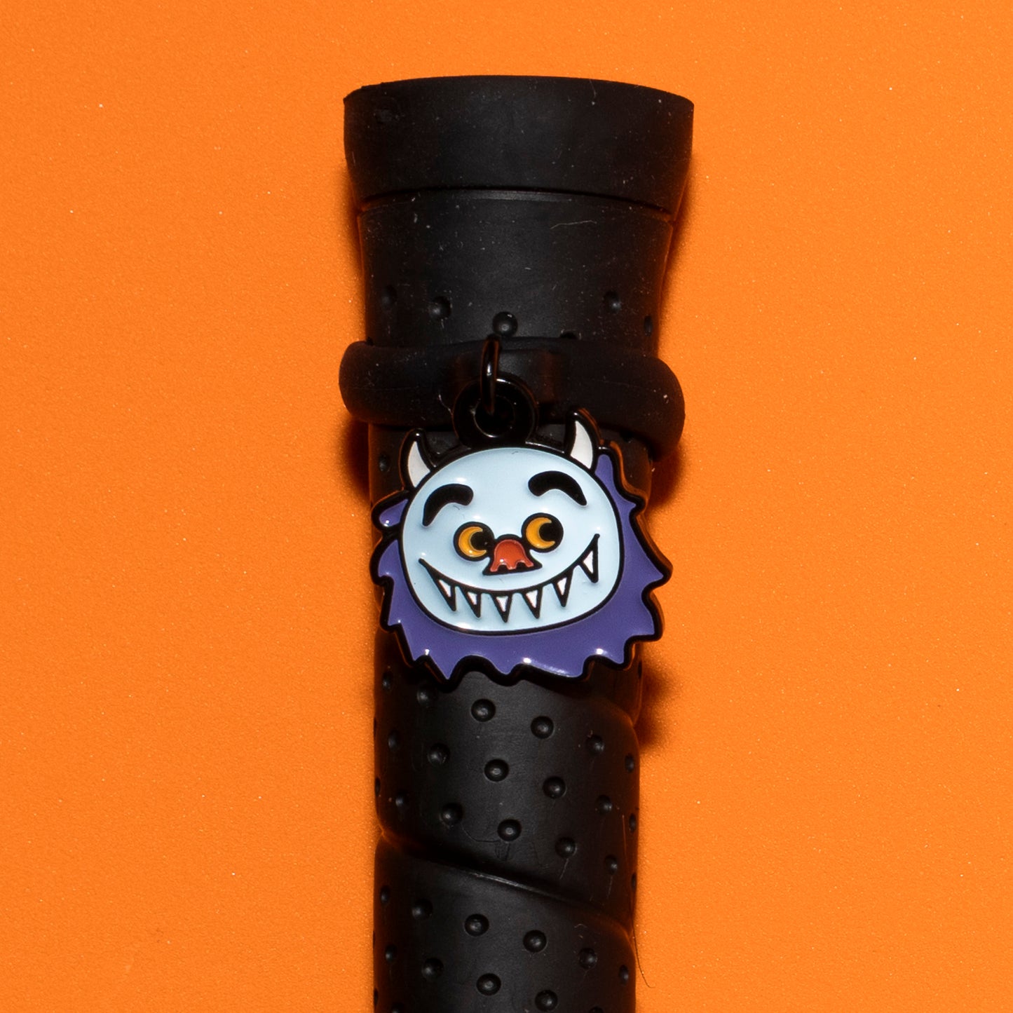 Pinsnickety Wild Thing crop charm on a whip handle in front of a colored background