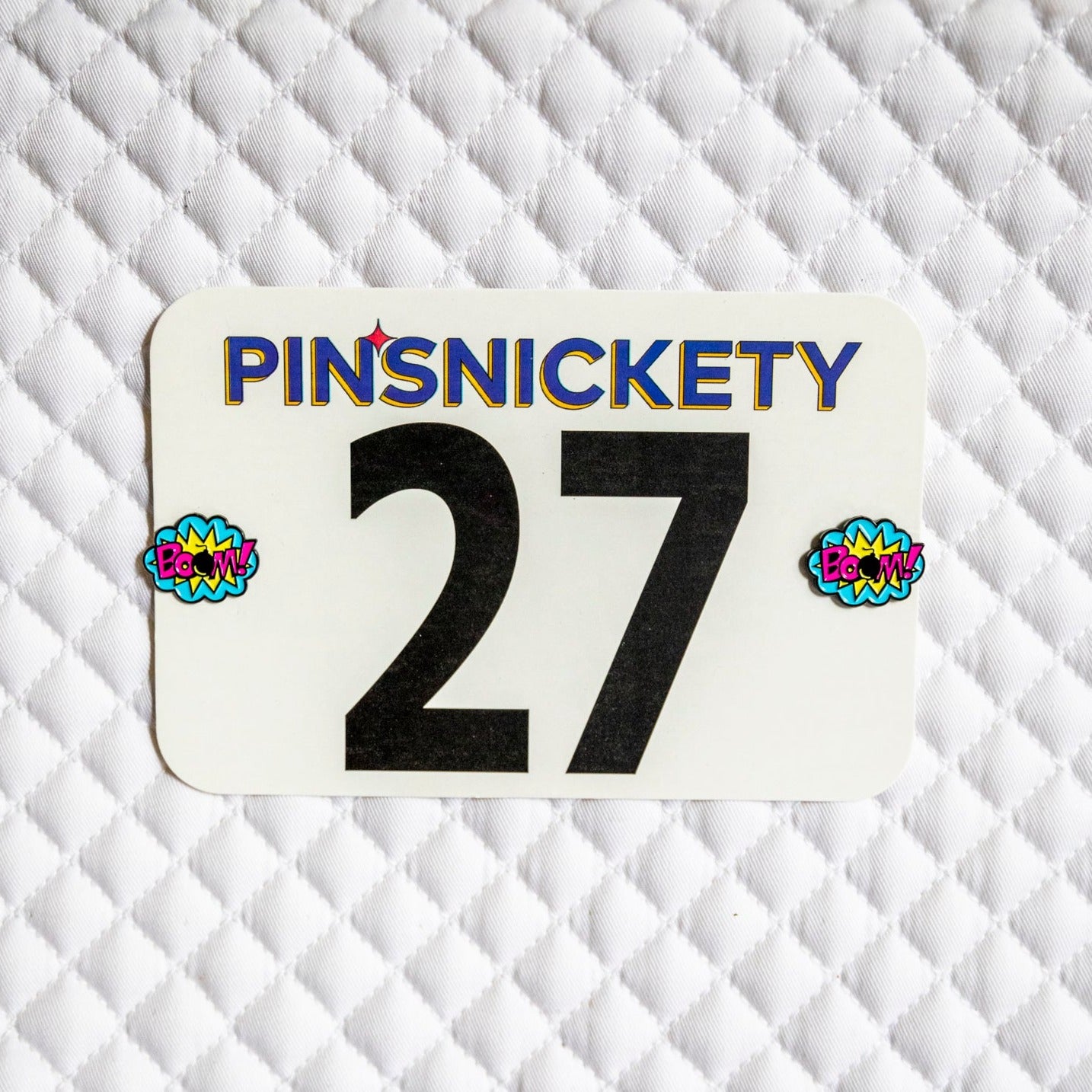 Pinsnickety BOOM! horse show number pins on a saddle pad.