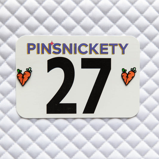 Pinsnickety Carrots horse show number pins on a saddle pad.