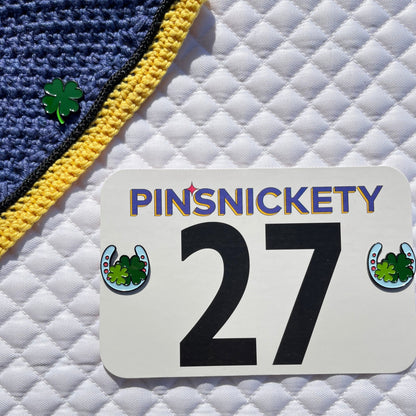 pinsnickety clover and horseshoe horse show number pins on a fly bonnet and saddle pad