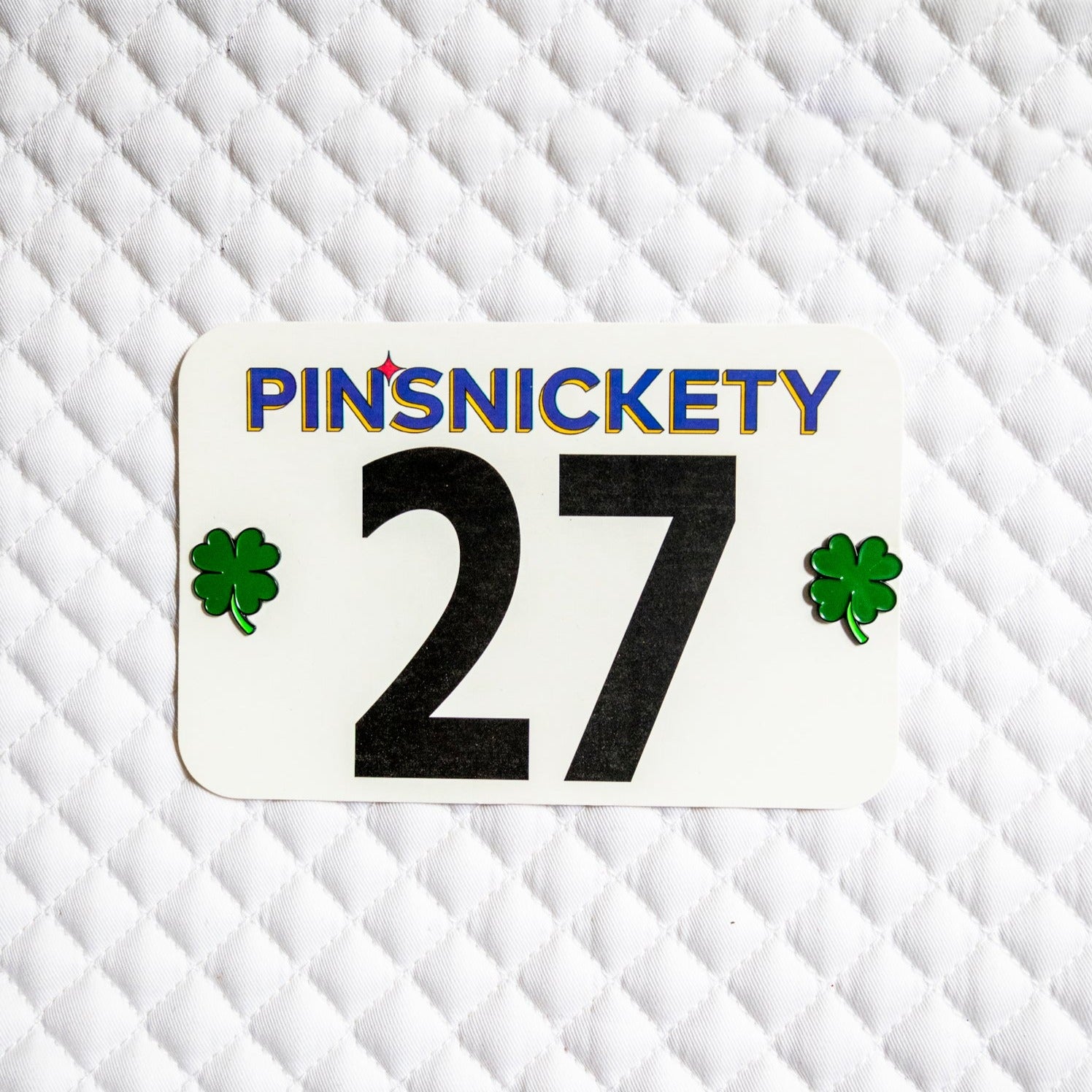 Pinsnickety Clover horse show number pins on a saddle pad