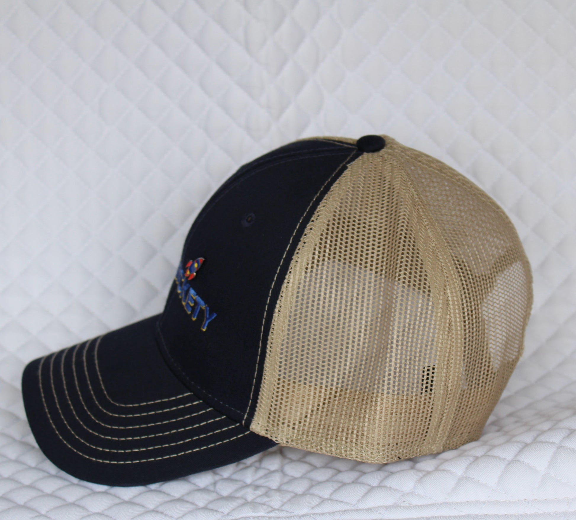 Side view of Pinsnickety's Trucker Hat, featuring a Mini Rocket Pin.